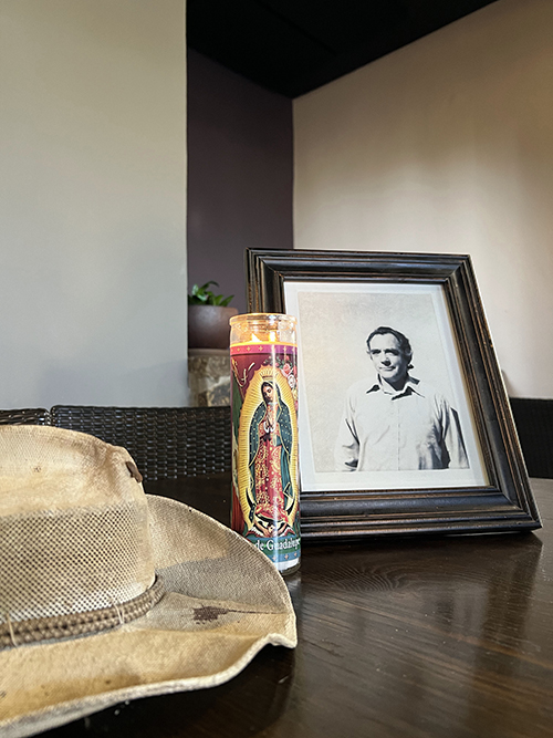 An older photo of Merv Larson is displayed with his brimmed hat in the Ocotillo Café